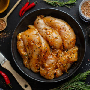 Juicy pomegranate-orange chicken garnished with fresh herbs, showcasing vibrant flavors and quality ingredients from The National Halal Meat