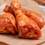 Raw marinated chicken drumsticks, featuring vibrant spices and herbs, highlighting quality and flavor from The National Halal Meat