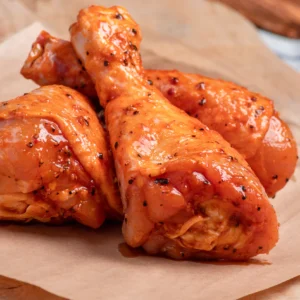Raw marinated chicken drumsticks, featuring vibrant spices and herbs, highlighting quality and flavor from The National Halal Meat